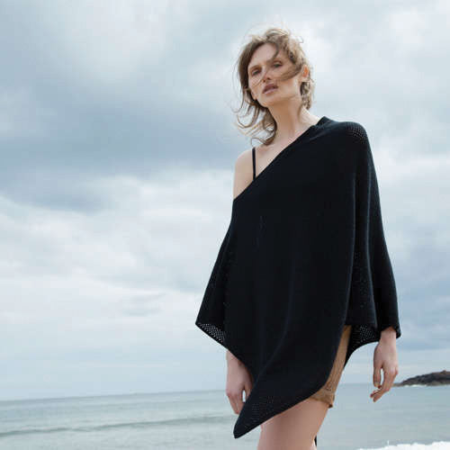 Woman wearing cashmere poncho at the beach