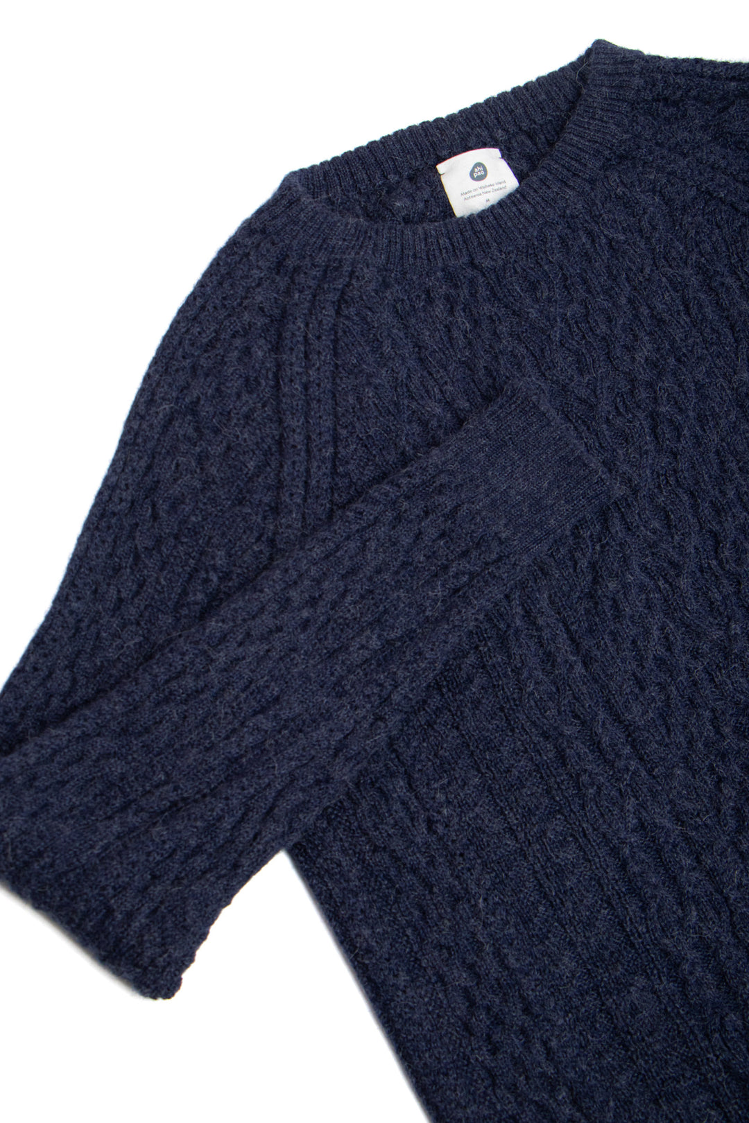 Navy blue cable knit sweater on a white background #colour_navy