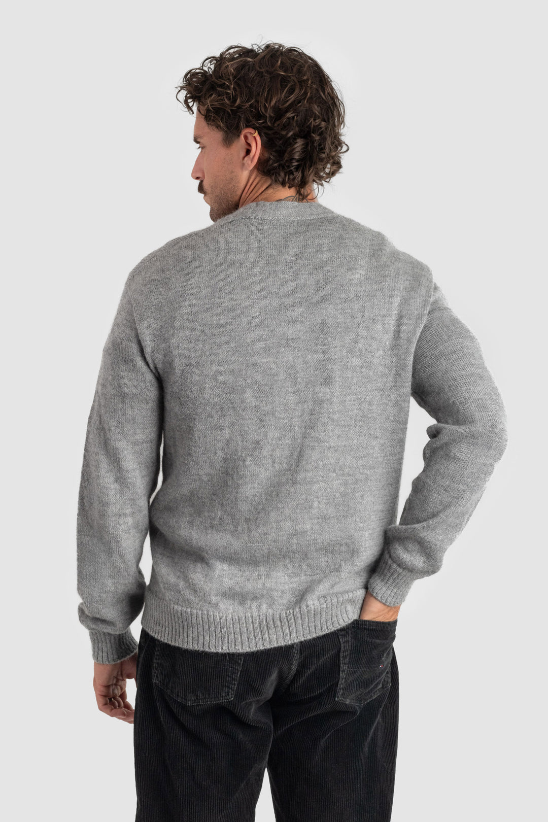 Person wearing a gray sweater and black pants on a white background #colour_cool-grey