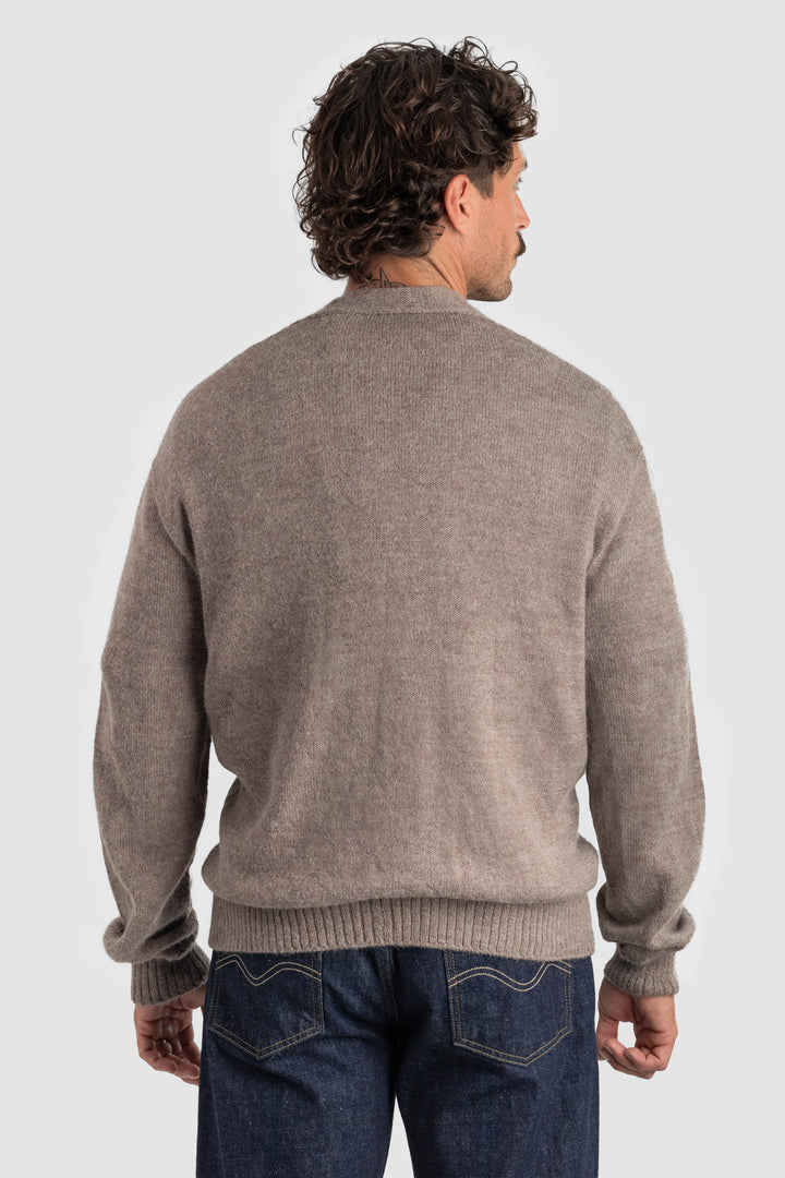 Man wearing a brown sweater and blue jeans on a white background #colour_fawn