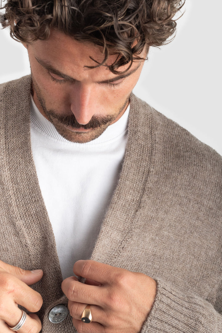 Man wearing a beige cardigan over a white shirt against a light background #colour_fawn